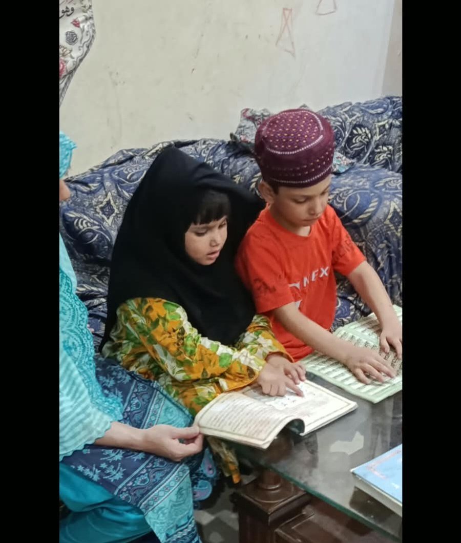 Teacher guiding children reading the Holy Quran at Ayat Quran Academy Faisalabad